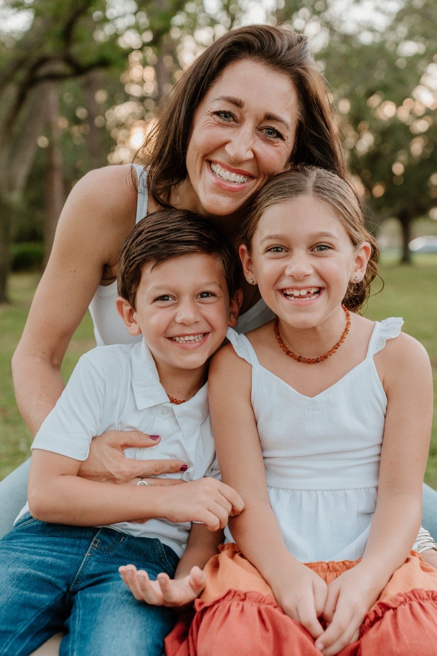 Mother smiling with two children outdoors