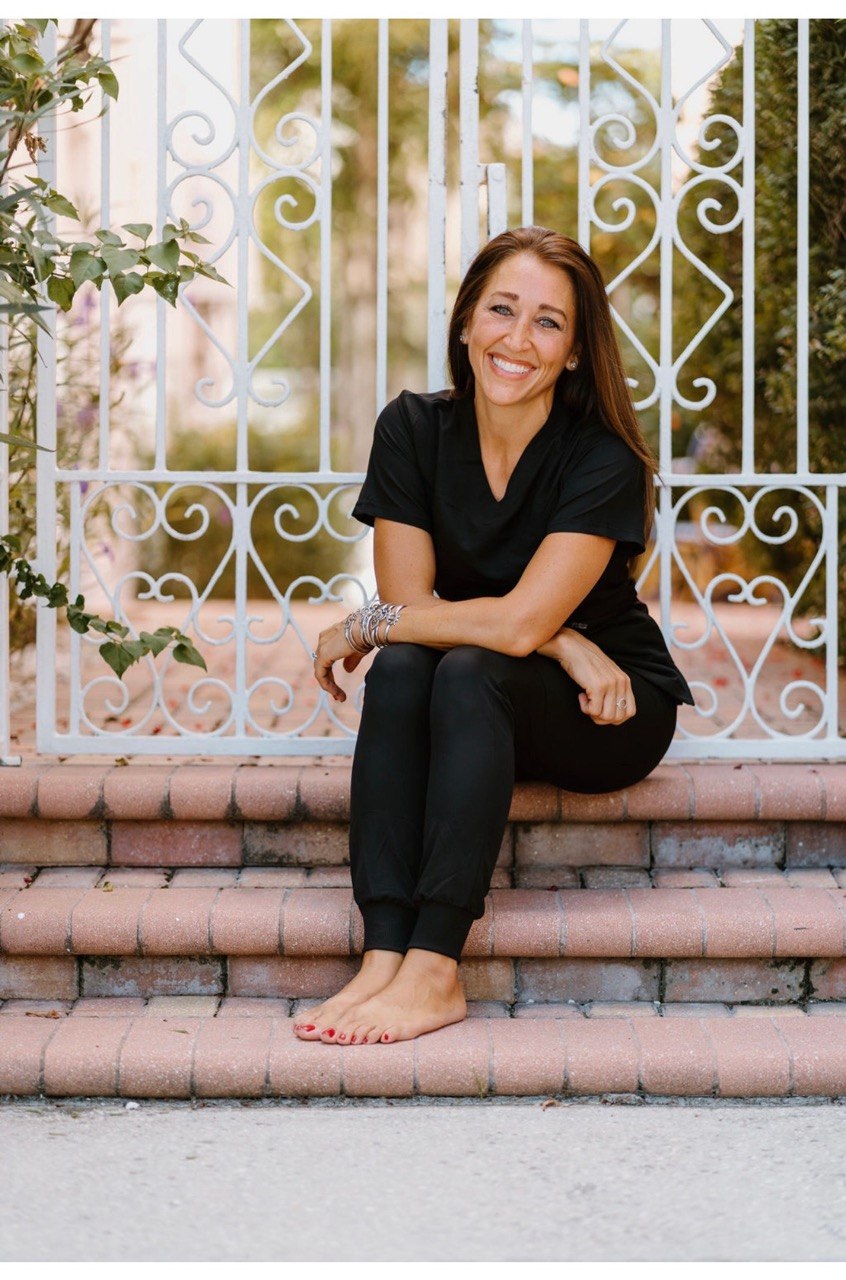 Doctor seated outdoors in black scrubs